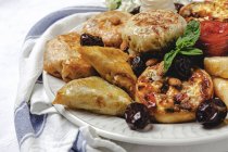 Alto ângulo de comida árabe saborosa variada com salsa e folhas de hortelã fresca perto de amêndoas durante as férias no Ramadã — Fotografia de Stock