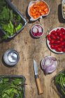 Вид зверху композиція з різних свіжих овочів, включаючи редьку вишневих помідорів цибулю і змішане листя салату на дерев'яному столі — стокове фото