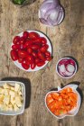 Top view composition of various fresh vegetables including radish cherry tomatoes onion on wooden table — Fotografia de Stock