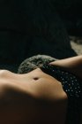 Крупный план живота женщины, которая лежит загорая в бикини — стоковое фото