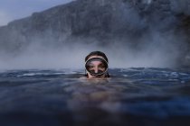 Femme avec lunettes plongeant dans la mer regardant la caméra — Photo de stock