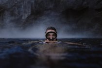 Mulher com óculos de mergulho no mar olhando para a câmera — Fotografia de Stock