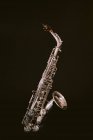 Сучасний класичний латунний духовий інструмент саксофон ізольований на чорному фоні в музичній студії — стокове фото