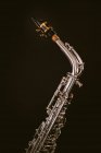 Contemporary classic brass wind instrument saxophone isolated on black background in musical studio — Stock Photo