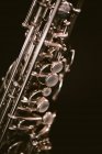 Saxofón clásico contemporáneo de instrumentos de viento de latón aislado sobre fondo negro en estudio musical - foto de stock