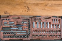 Dall'alto della vecchia scatola con cacciavite e vari ugelli e chiavi per il servizio di manutenzione e riparazione auto su tavolo in legno — Foto stock