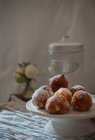 Homemade custard cream fritters covered with sugar on rustic wooden table with table cloth and leafs decoration — Stock Photo