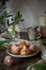 Hausgemachte Puddingcreme-Krapfen mit Zucker bedeckt auf rustikalem Holztisch mit Tischdecke und Blätterdekoration — Stockfoto