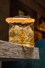 Taza de vidrio Tiki con bebida pasada de moda colocada en la mesa sobre fondo borroso - foto de stock