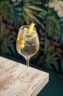 Сверху хрустальные бокалы с коктейлем Мартини с лимонной цедрой и оливковыми краями деревянного стола — стоковое фото