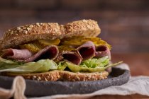 Gros plan d'un délicieux sandwich pastrami, laitue, jambon et cornichon — Photo de stock