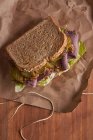 Primo piano di un delizioso panino con pastrami, lattuga, prosciutto e sottaceti — Foto stock