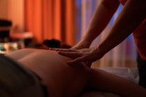 Cultivar massagista irreconhecível amassar ombros de senhora feliz durante a sessão de spa no salão — Fotografia de Stock