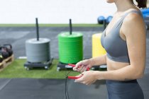 Ernte unkenntlich schlanke Frau in Sportkleidung macht Übung mit Springseil beim funktionellen Training im Sportverein — Stockfoto