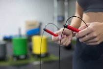 Crop unrecognizable slim female in sportswear doing exercise with jumping rope during functional workout in sports club — Stock Photo