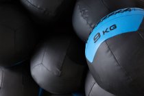Set schwarze Medizinbälle für funktionelles Training in Reihen an der Wand in einem modernen Sportverein gestapelt — Stockfoto