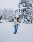 Молода щаслива жінка стоїть на зимовому сніговому парку з білими деревами в Мадриді з закритими очима. — стокове фото