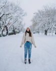 Jovem mulher feliz em pé no parque de neve de inverno com árvores brancas em Madrid com os olhos fechados — Fotografia de Stock