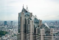 View to high skyscrapers towers and small buildings in big city — Stock Photo