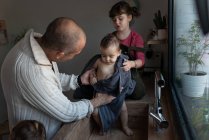 Vater und kleines Mädchen wischen niedliche nackte Kleinkind mit Handtuch nach dem Baden im Waschbecken in der Küche — Stockfoto