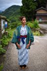 Portrait d'une jeune femme caucasienne contemplative portant un kimono japonais traditionnel dans le petit village d'Ainokura, au Japon — Photo de stock