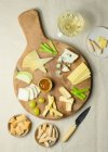 From above various cut cheese on wooden board with croutons placed on table — Stock Photo