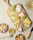 From above various cut cheese on wooden board with croutons placed on table — Stock Photo