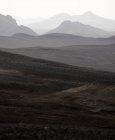 Malerische Landschaft einer rauen Bergkette mit Gipfeln im dichten Nebel unter düsterem Himmel im Hochland — Stockfoto