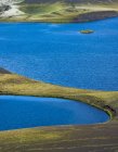 Desde arriba de pintoresco paisaje de brillante río azul que fluye entre el terreno volcánico en Islandia - foto de stock