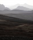 Pintoresco paisaje de cordillera áspera con picos en densa niebla bajo el cielo sombrío en las tierras altas - foto de stock