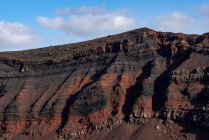 Вид на скелясті вулканічні утворення в оточенні горбистої сухої гори — стокове фото