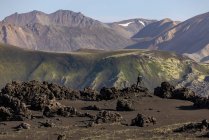 Vista panoramica di formazioni rocciose vulcaniche grezze circondate da monti collinari asciutti — Foto stock