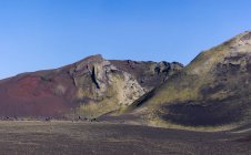 Paisagem espetacular de terreno rochoso sem fim com declives secos e vegetação aleatória localizada sob céu azul claro na Islândia — Fotografia de Stock