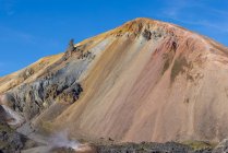 Spettacolare paesaggio di infiniti terreni rocciosi accidentati con pendii asciutti e vegetazione casuale situata sotto il cielo blu chiaro in Islanda — Foto stock