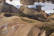 Pintoresca vista de la vasta tierra montañosa cubierta de hierba seca y nieve en la naturaleza pacífica a la luz del día - foto de stock
