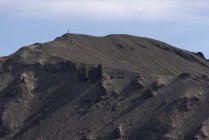 Vista panorámica de formaciones volcánicas rocosas ásperas rodeadas por una montaña montañosa y seca - foto de stock