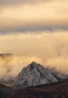 Magnifico scenario di montagne rocciose con cime illuminate dalla luce del sole in terreni desertici accidentati durante il tramonto — Foto stock