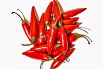 Composição de vista superior com pimentas exóticas frescas vermelhas usadas como tempero ou condimento para dar sabor a alimentos em fundo branco — Fotografia de Stock