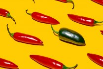 Von oben frische reife Chilischoten mit scharfem grünem Gemüse verschiedener Art auf gelbem Hintergrund — Stockfoto