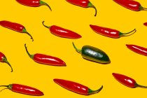 Von oben frische reife Chilischoten mit scharfem grünem Gemüse verschiedener Art auf gelbem Hintergrund — Stockfoto