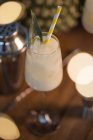 De la composition ci-dessus des cocktails classiques sucrés Pina Colada servis sur le comptoir du bar près de shaker et jigger — Photo de stock
