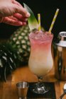 Ernte gesichtslose Person bereitet köstlichen erfrischenden Pina Colada Cocktail auf dem Tisch serviert — Stockfoto