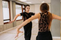 Couple of talented dancers moving gracefully while rehearsing ballroom dance in hall during lesson — Stock Photo