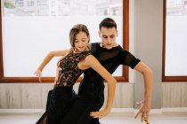Couple of talented dancers moving gracefully while rehearsing ballroom dance in hall during lesson — Stock Photo