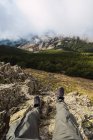 Crop turista anonimo in abbigliamento casual sdraiato su terreni accidentati contro le montagne durante il viaggio in Spagna — Foto stock
