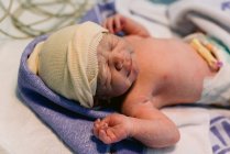 Close-up newborn baby wrapped in blanket after labor in hospital — Stock Photo