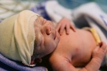 Close-up newborn baby wrapped in blanket after labor in hospital — Stock Photo