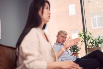Unzufriedene Asiatin greift gleichgültigen Mann während Therapiesitzung im Büro des Psychologen an — Stockfoto