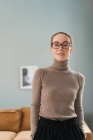 Улыбающаяся самоуверенная женщина-консультант, стоящая с руками в карманах в офисе для сеансов психотерапии и смотрящая в камеру — стоковое фото