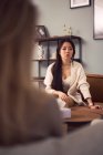 Mulher asiática preocupada sentada no sofá e ouvindo conselhos de psicóloga durante a terapia mental — Fotografia de Stock